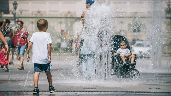 A child plays in a water fountain