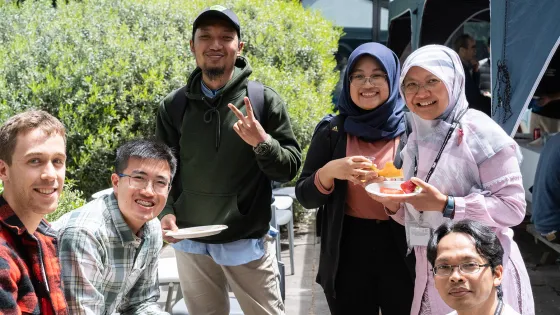 Students sitting outside while enjoying a meal.