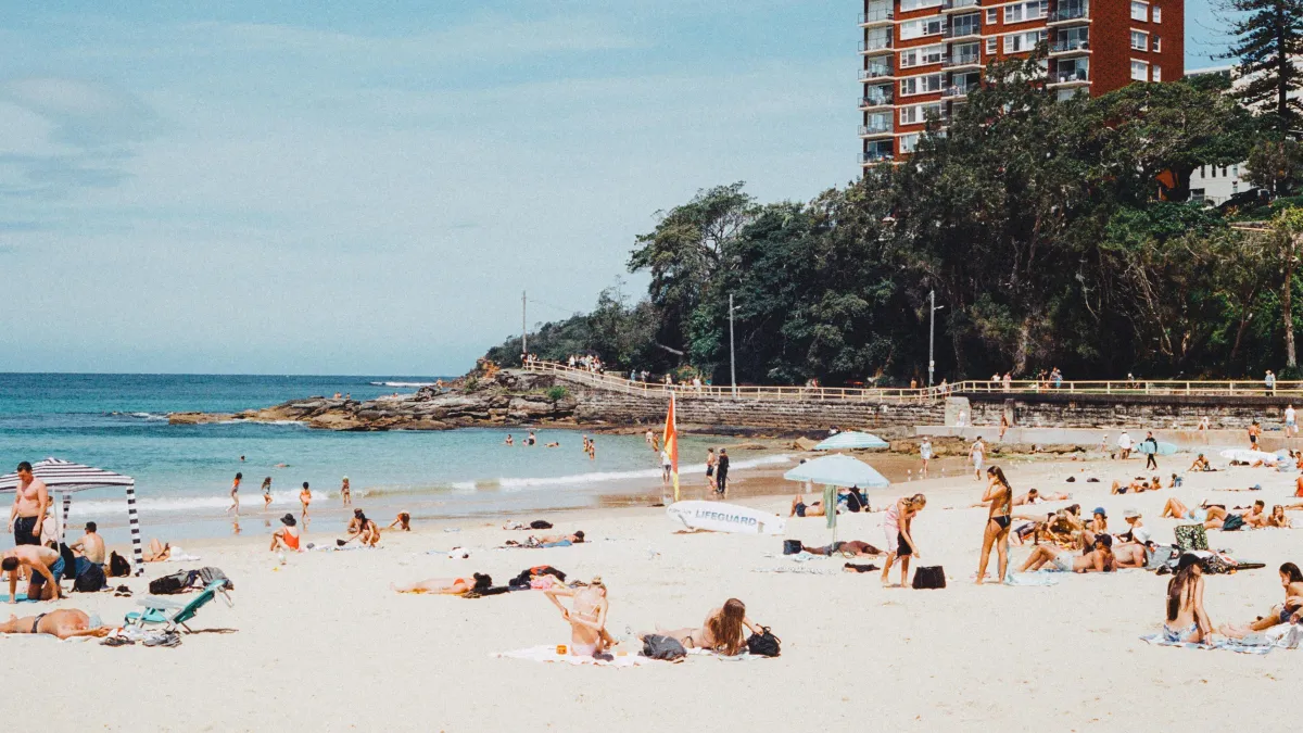 People on a beach in front of high rise buildings