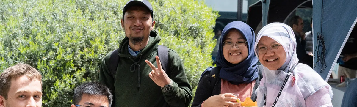 Students sitting outside while enjoying a meal.