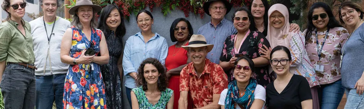 A group of academics, students and staff gather for a photo.