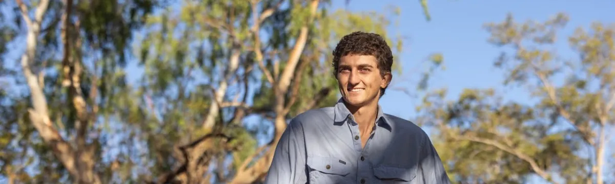 Marcus Dadd stands in a woodland.