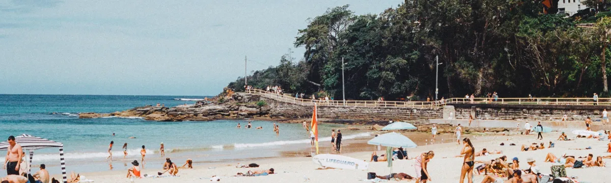 People on a beach in front of high rise buildings