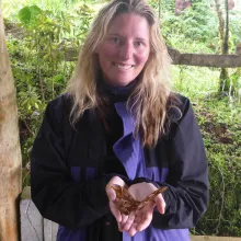 Suzi Bond cups a butterfly in her hands