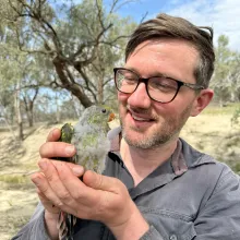 Thomas Hunt holding a parrot.