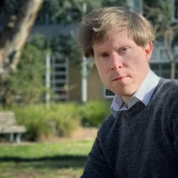 Ben sits in a garden at ANU.
