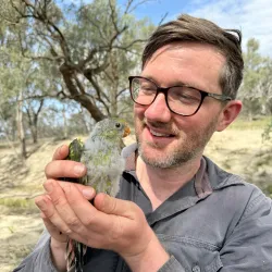 Thomas Hunt holding a parrot.