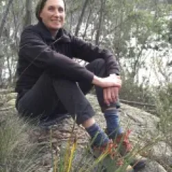 Lisa Robins sits on a rock and looks at the camera