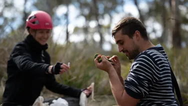 Two researchers doing field work on a forest floor in Tasmania.