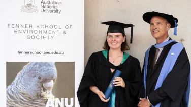 A student poses for a photo in her graduation attire with her supervisor.