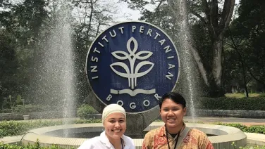 Dominique Holani standing outside university fountain