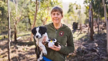 An ecologist holds her dog, Zorro.