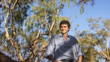 Marcus Dadd stands in a woodland.
