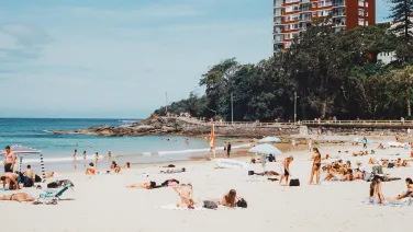 People on a beach in front of high rise buildings